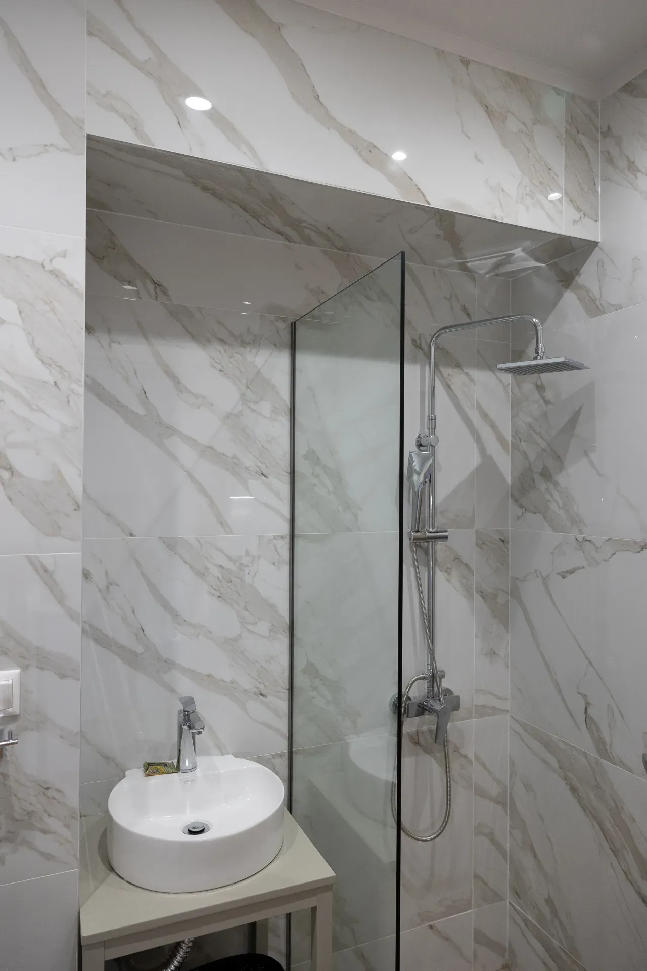 Glass-enclosed shower and washbasin