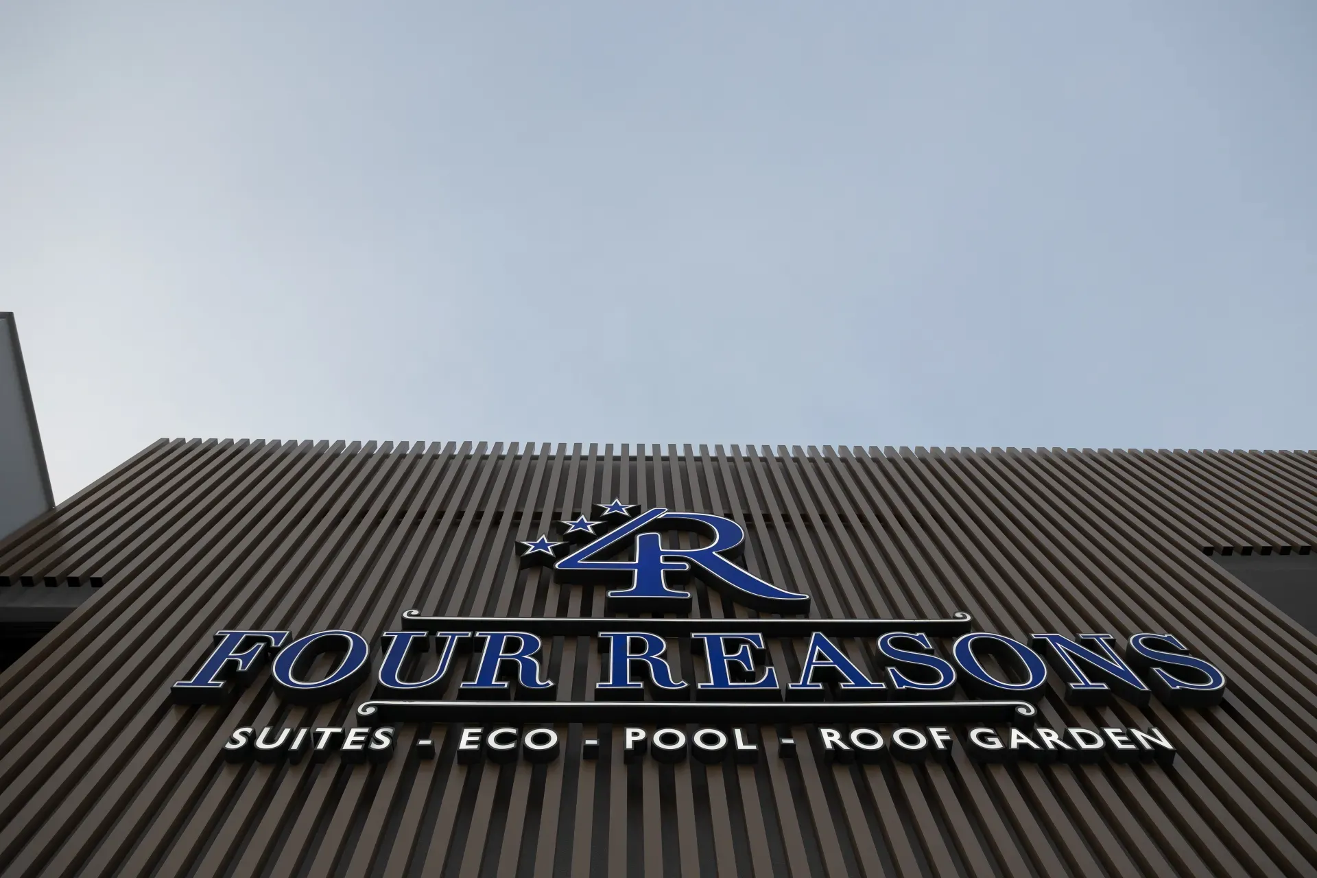 The Four Reasons illuminated sign on the building façade