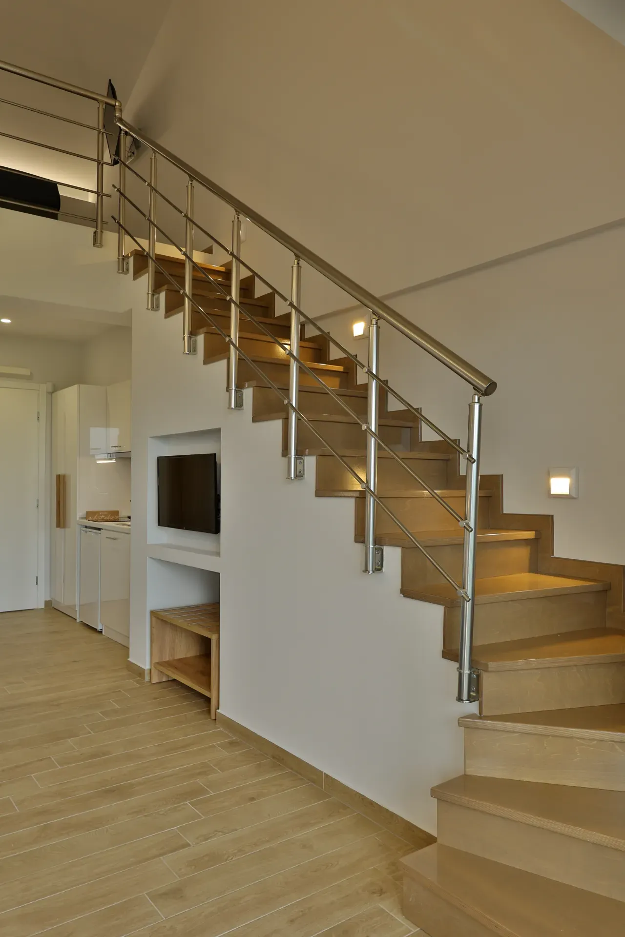 Wooden staircase and kitchen in the Two-storey Suite