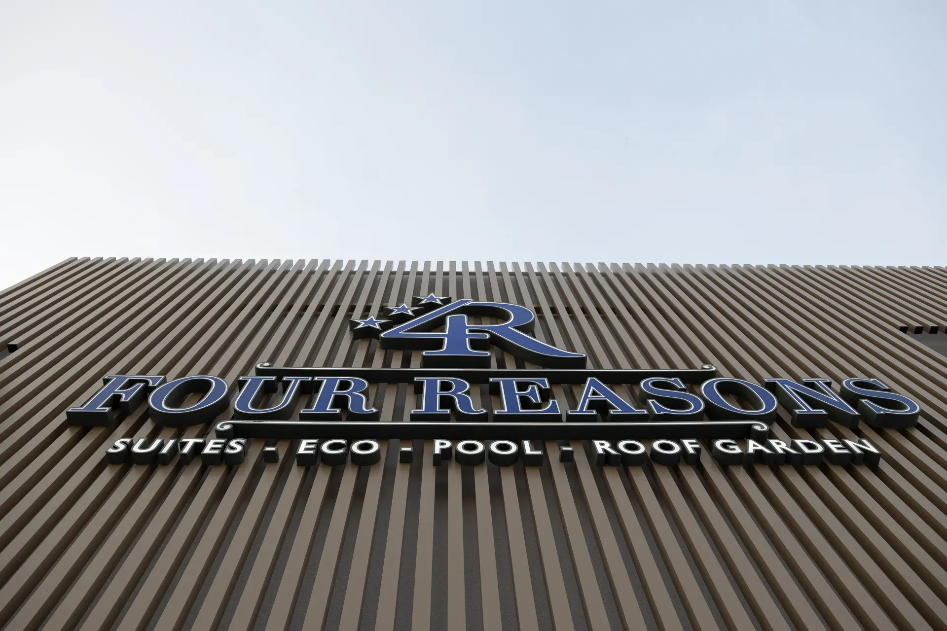 The Four Reasons illuminated sign on the façade