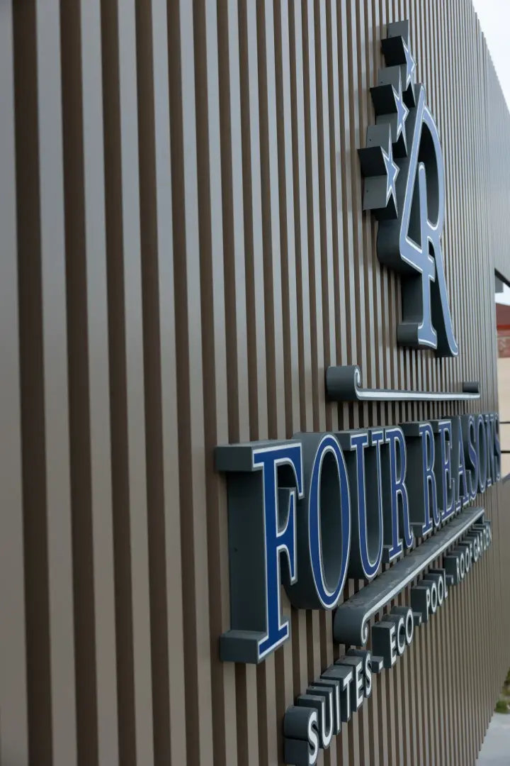The Four Reasons Apartments façade with its illuminated sign